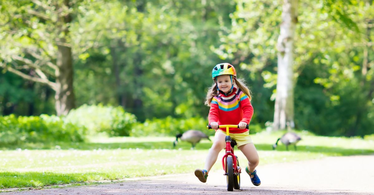 Pige kører på en løbecykel
